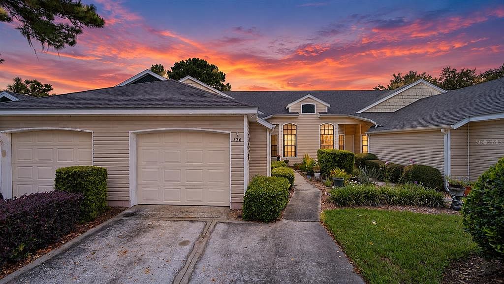 Front of the villa at dusk, with the one-car garage and landscaped walkway